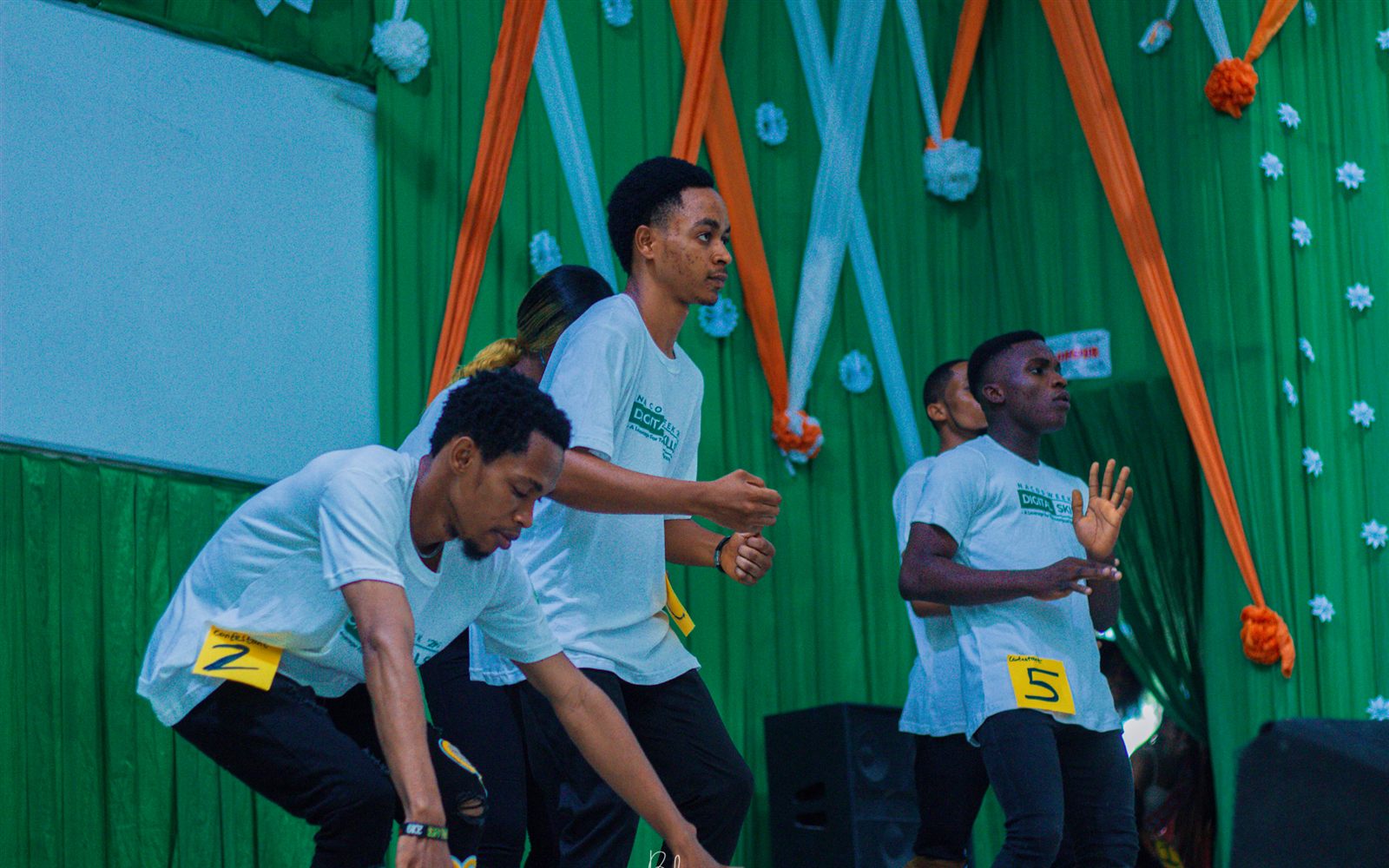 Contestants dancing on stage at a previous NACOS Week