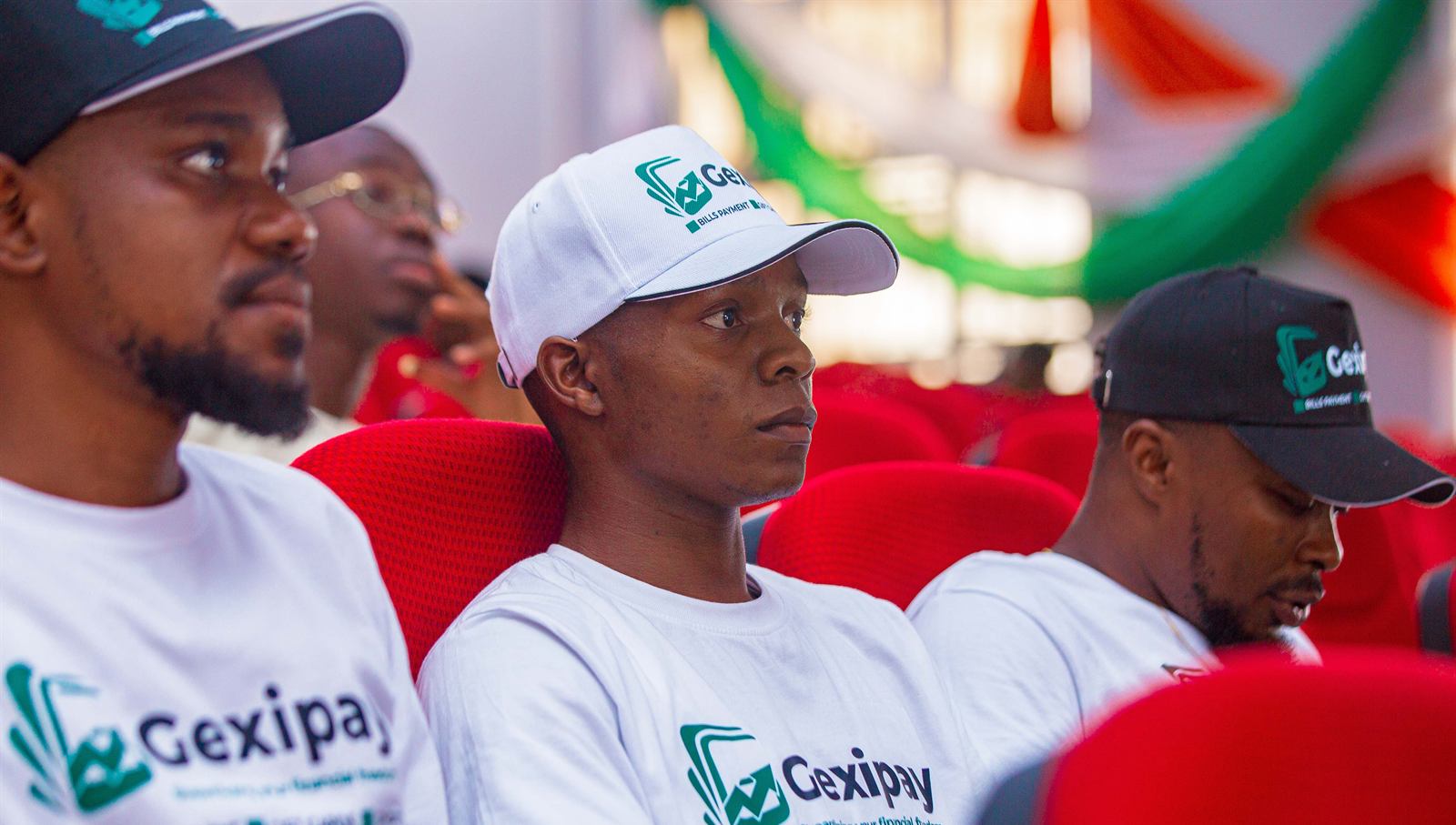 Students in branded caps and shirts in the audience
