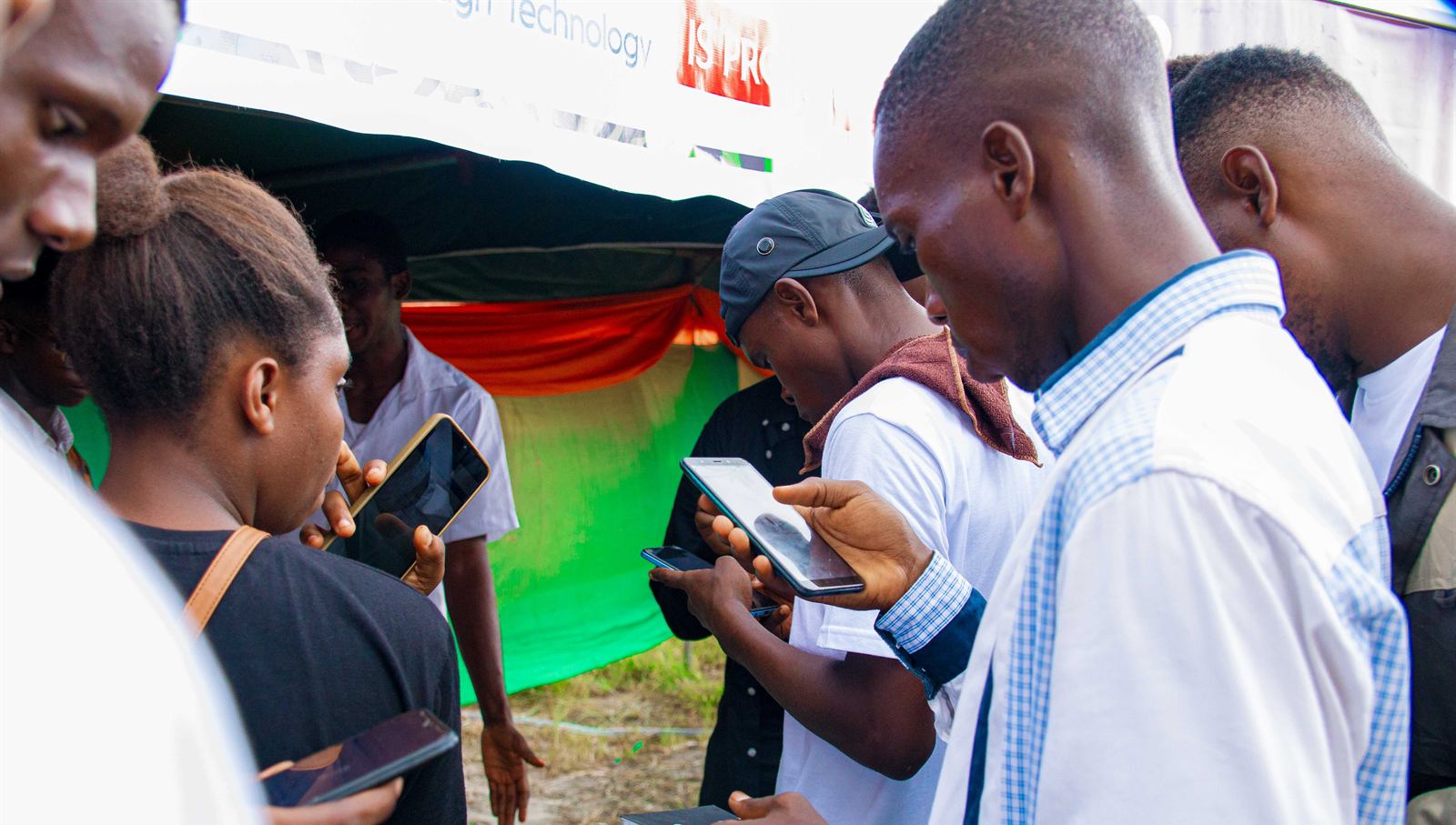Students checking their phones at an outdoor booth
